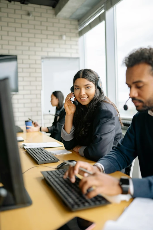 two smiling workers on cellphones in a call center