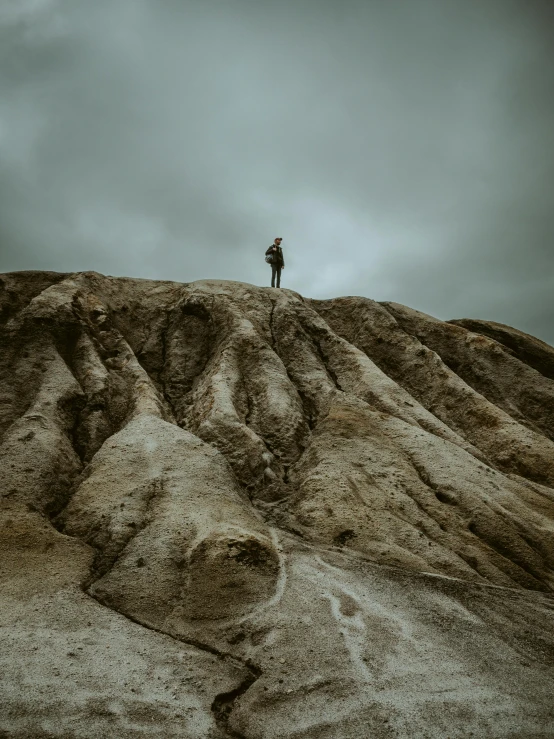 a person stands on top of a rocky hill