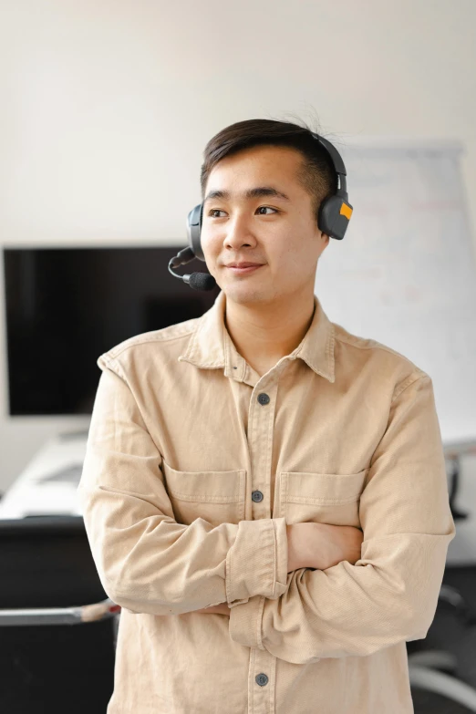 an asian man with a headset in front of a desk