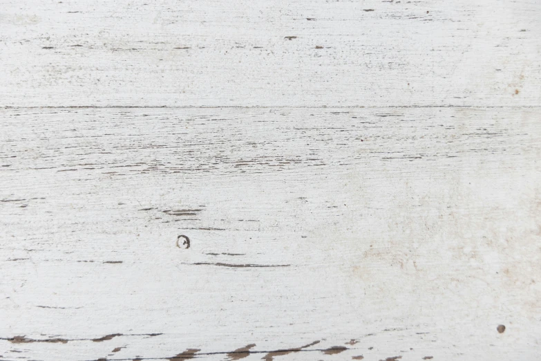 a white wooden surface with scratches and holes