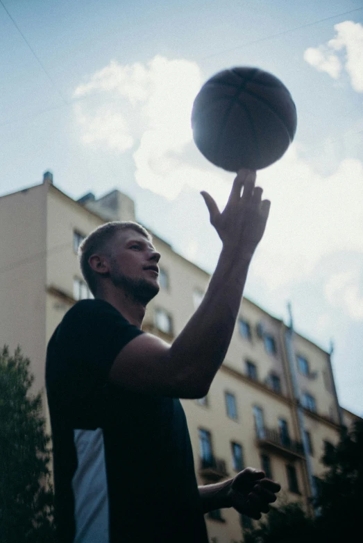 man spinning up a basketball while looking upward