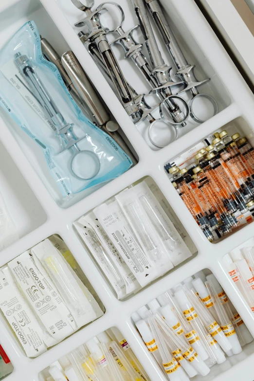 scissors, tubes, and surgical implements are laying out in a drawer