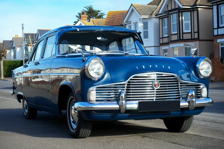 a vintage blue station wagon parked on the side of the road