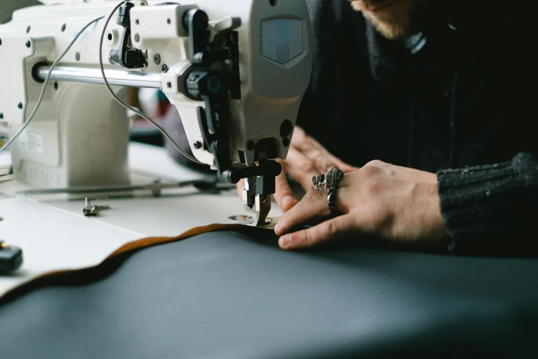 a man that is sitting next to a sewing machine