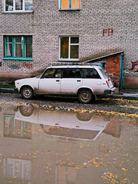 a car parked in front of a brick building with a flatbed