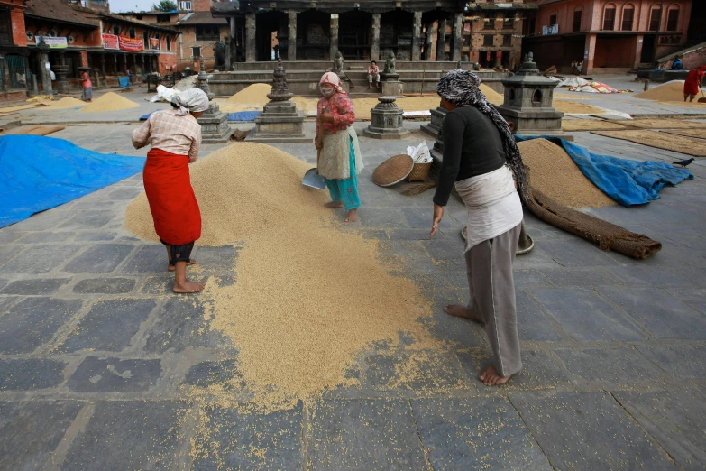 three people standing around with an area full of sand