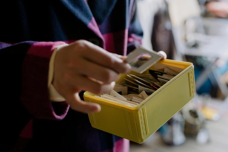 a hand holding a metal toolbox full of tools