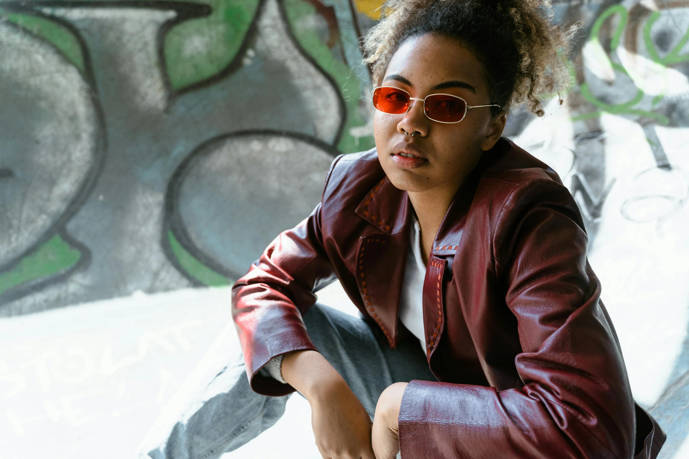 a woman wearing sunglasses and a leather jacket