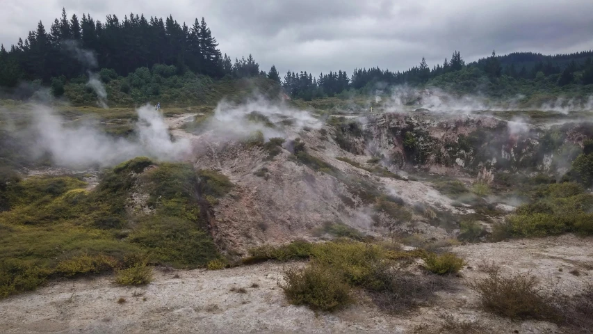  springs surrounded by fog and trees under a cloudy sky