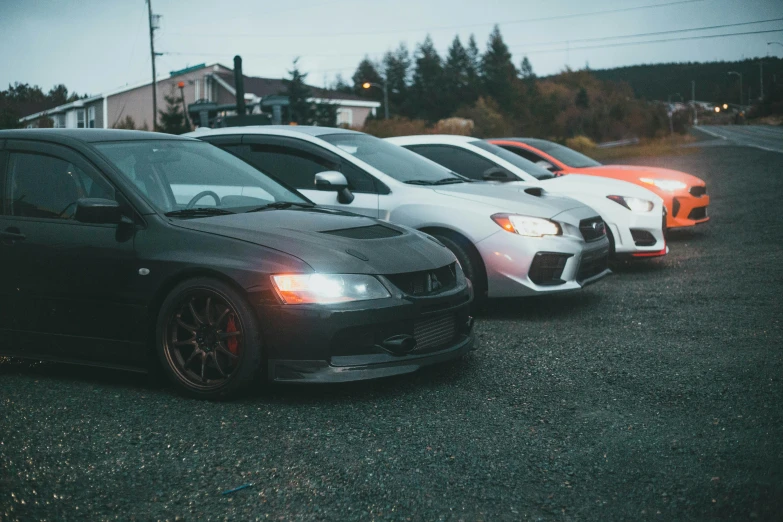 three different cars parked together in a lot