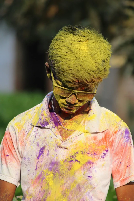 a person with yellow, orange and blue dyed hair standing outside