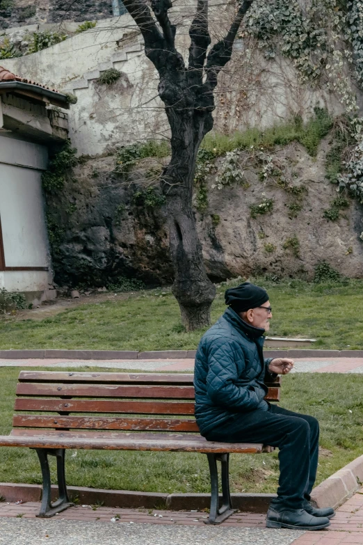 a man sitting on a park bench smoking a pipe