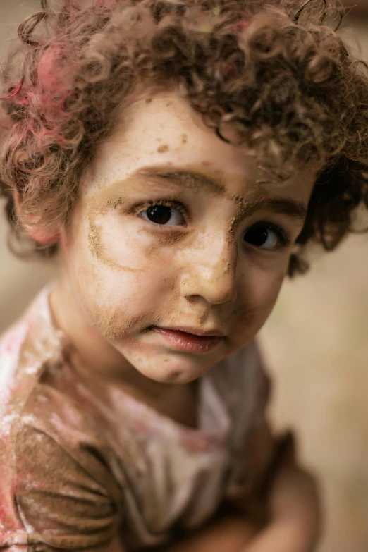 a child's face covered in dirt and smeared with makeup