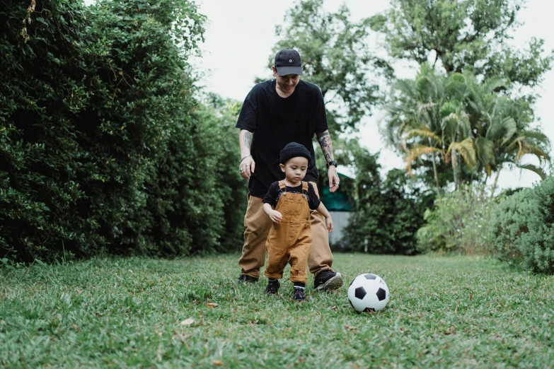 a  kicks the soccer ball next to an adult