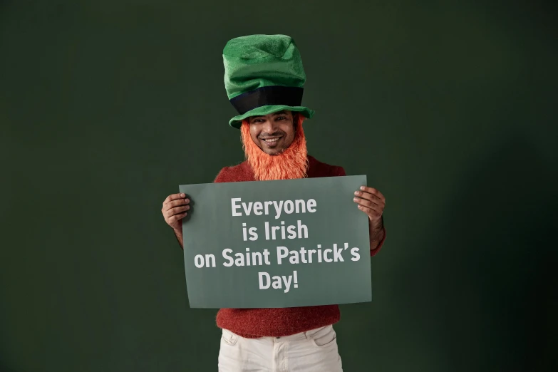 an irish man wearing a hat and holding up a sign