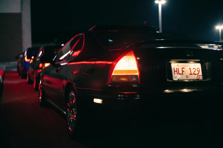 there are two parked cars on the street at night