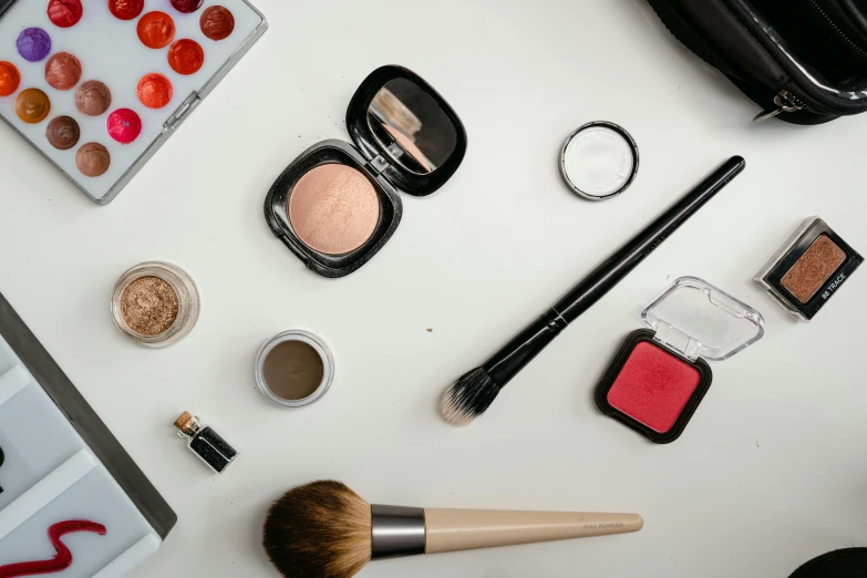 a counter top with cosmetics, makeup brush and other objects