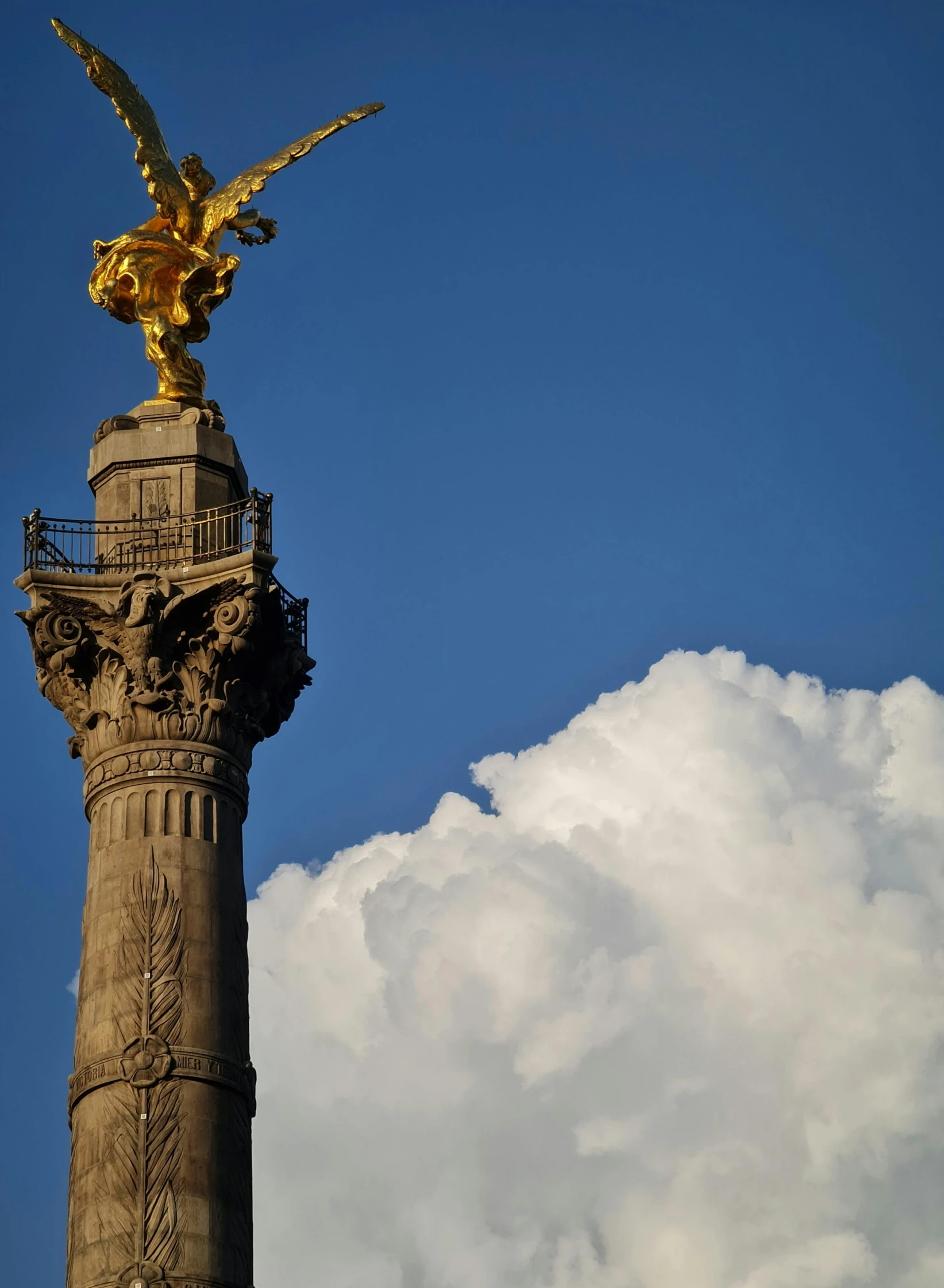 there is a golden bird that is atop this statue