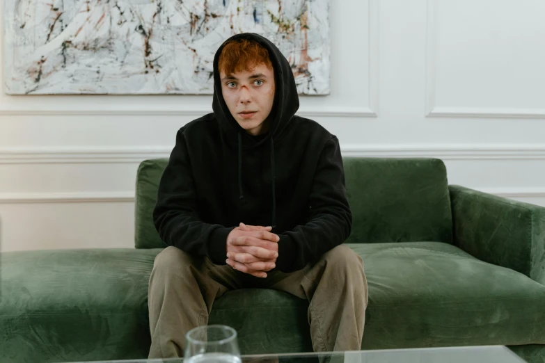 a person wearing a hoodie sitting on a couch