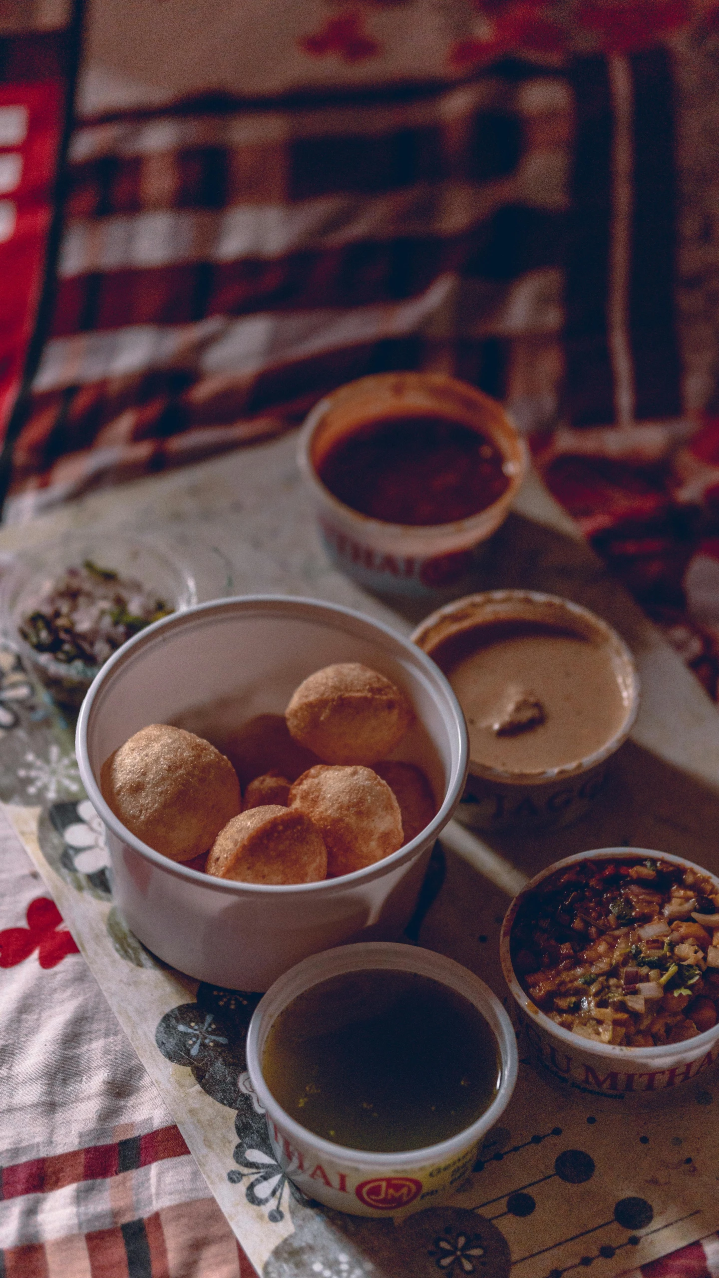 three bowls that have food in them on a bed