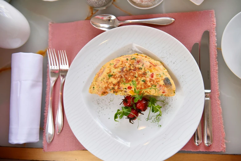 an omelet with some fruit on top is sitting on a plate