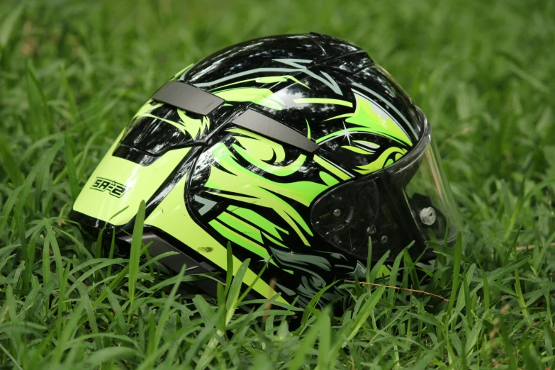 the helmet sits in the grass with the black and yellow pattern