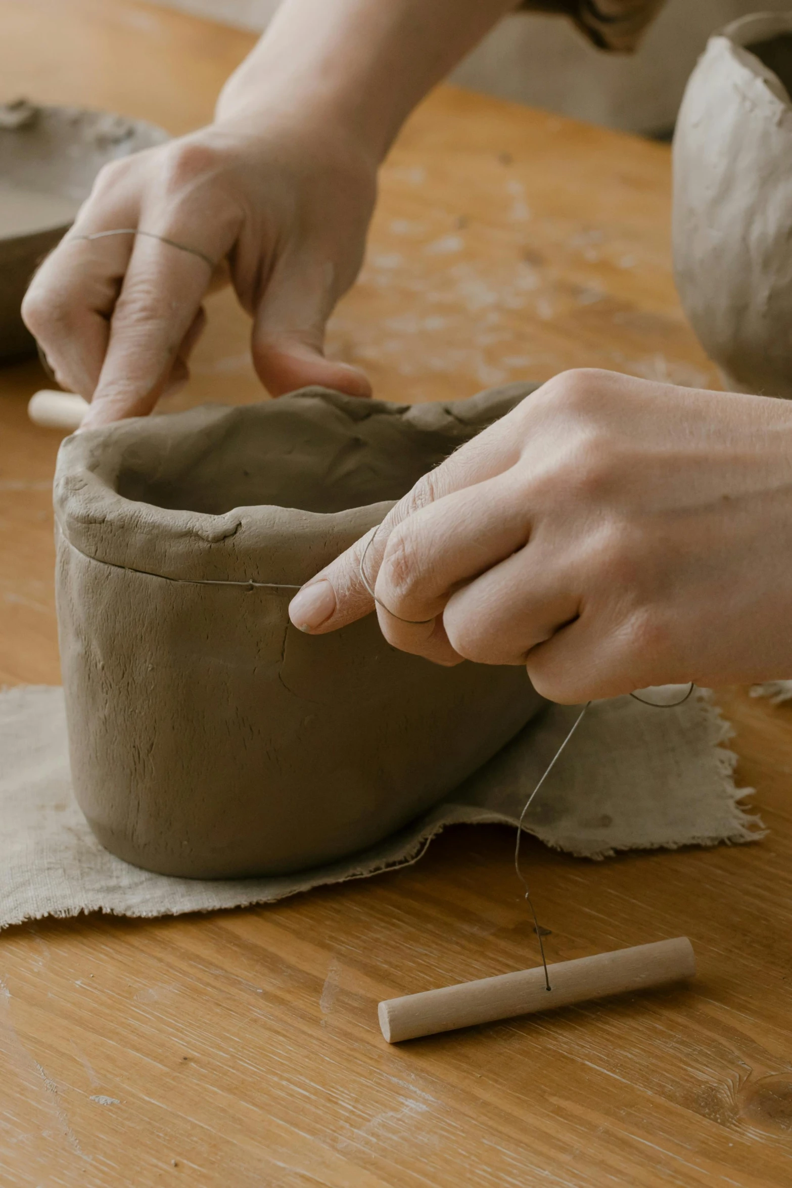 person decorating pot being made on table