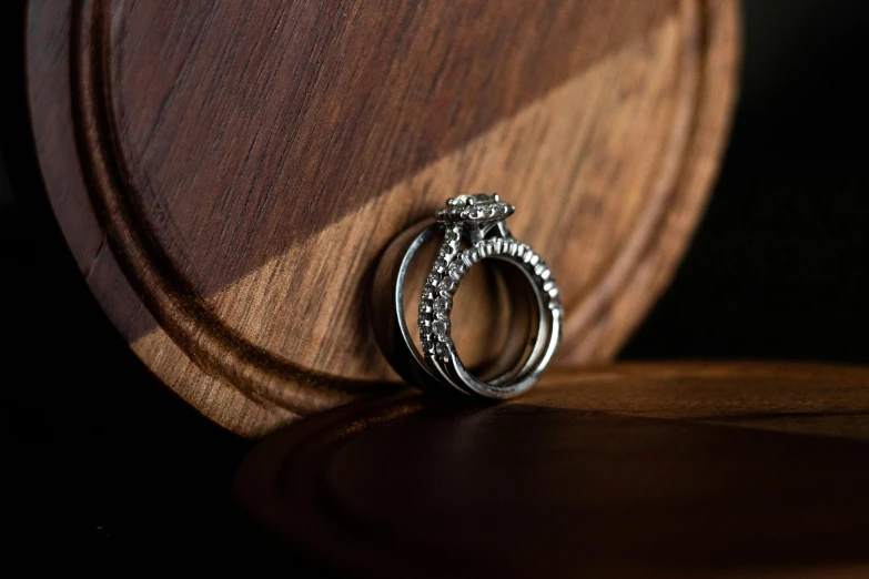 a ring with diamonds is shown on top of a wooden box