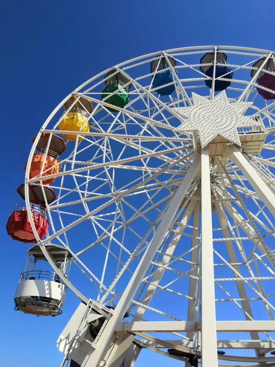 a colorful ferris wheel with the sky behind it