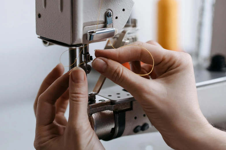 person using a sewing machine on the handle of a piece of material