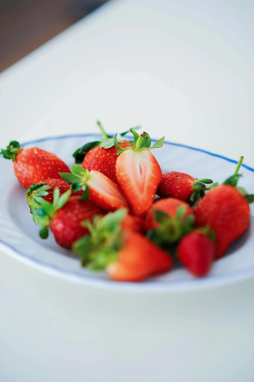 a bunch of strawberries on a white and blue plate