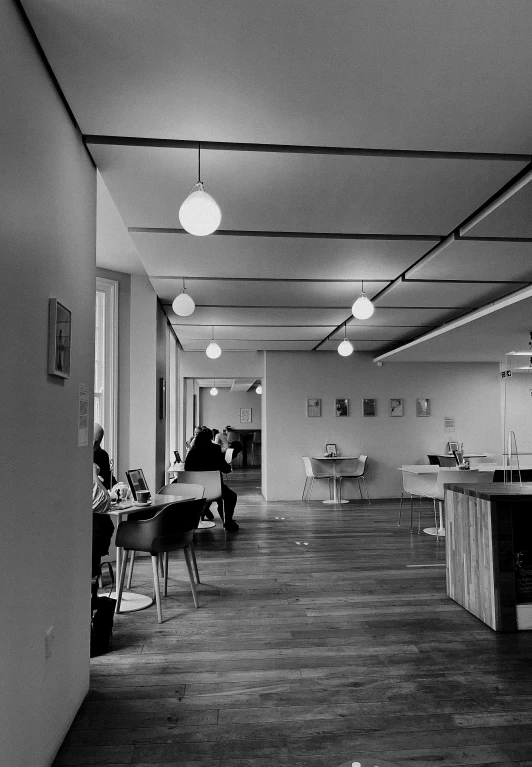 a man is sitting down in a room with tables and a bar