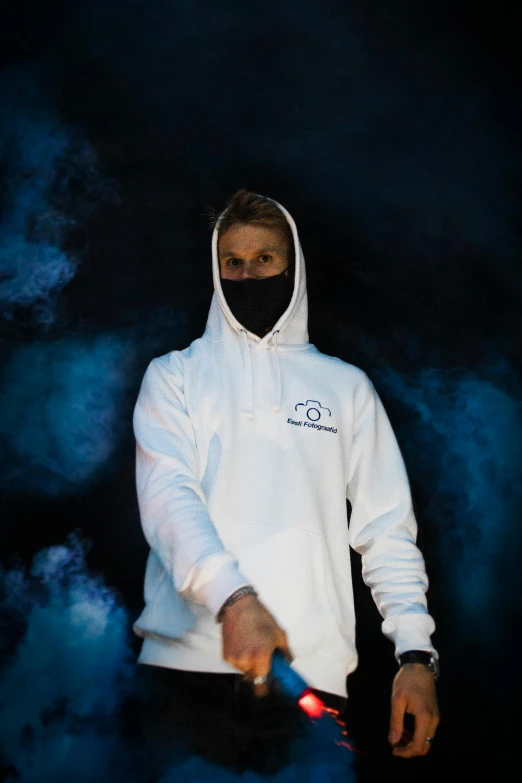 a person in white hooded jacket smoking soing with smoke behind them