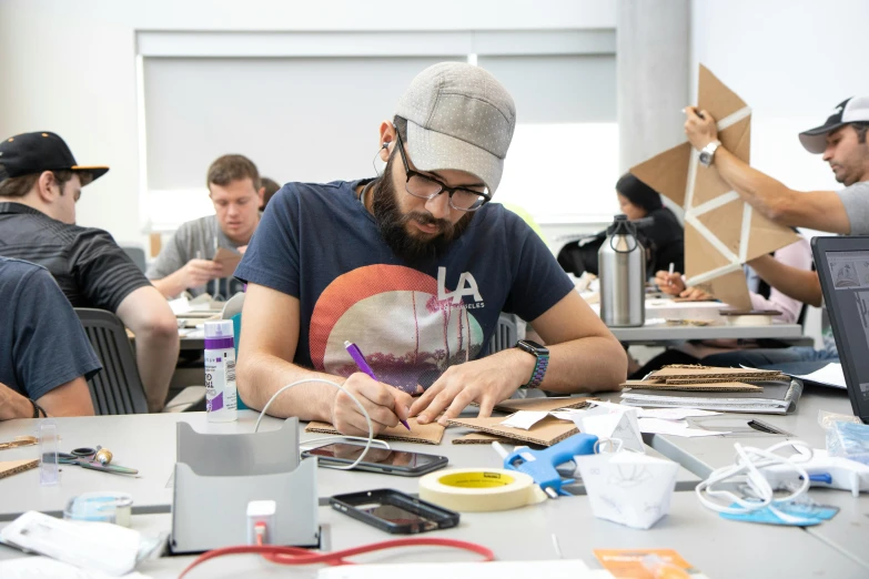 a man with a beard is doing crafts in a room