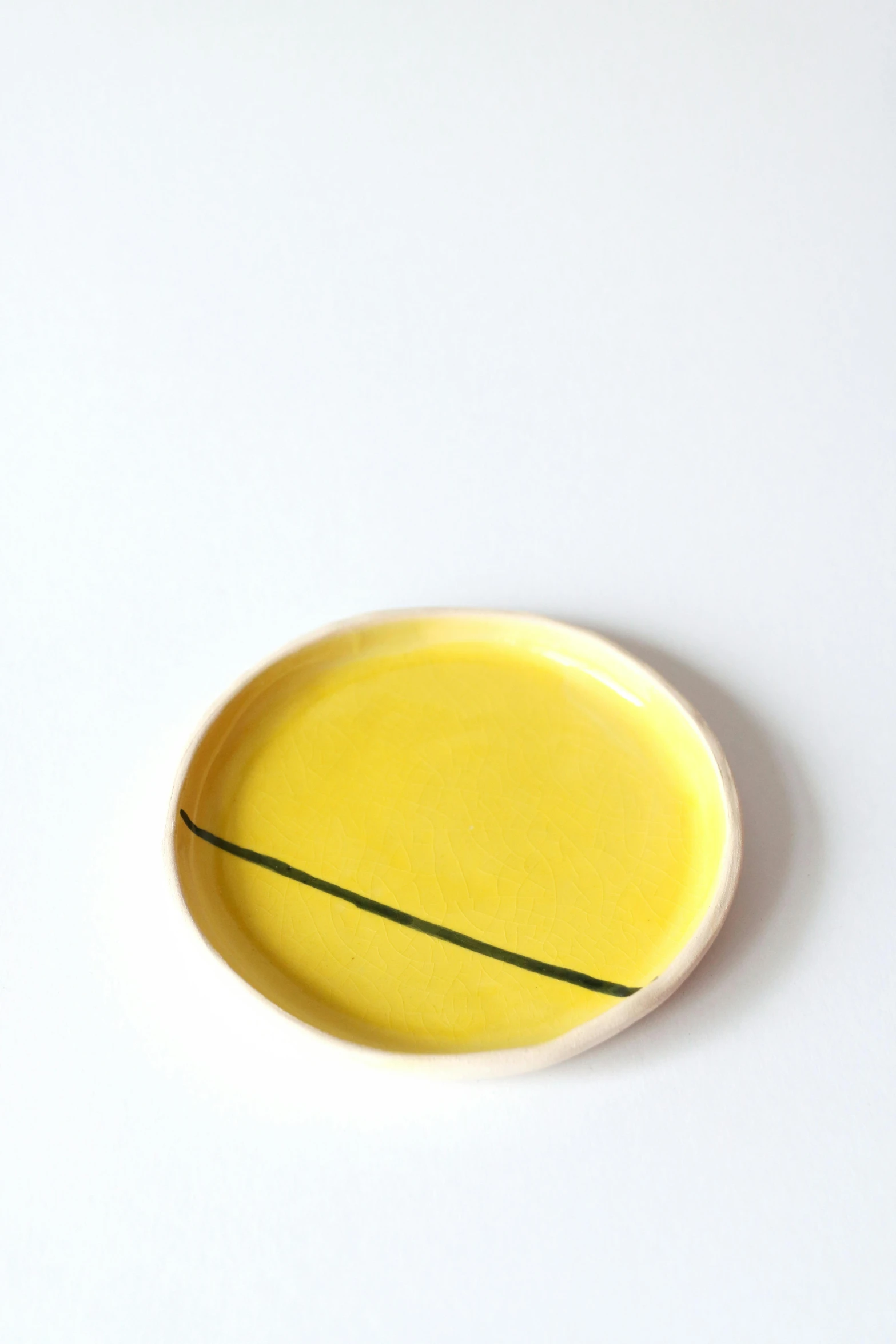 a yellow bowl with a small thin line painted on it