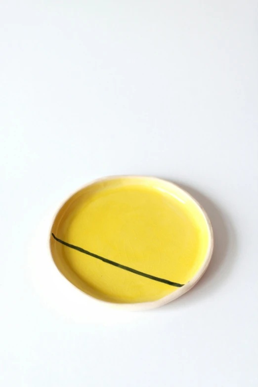 a yellow bowl with a small thin line painted on it