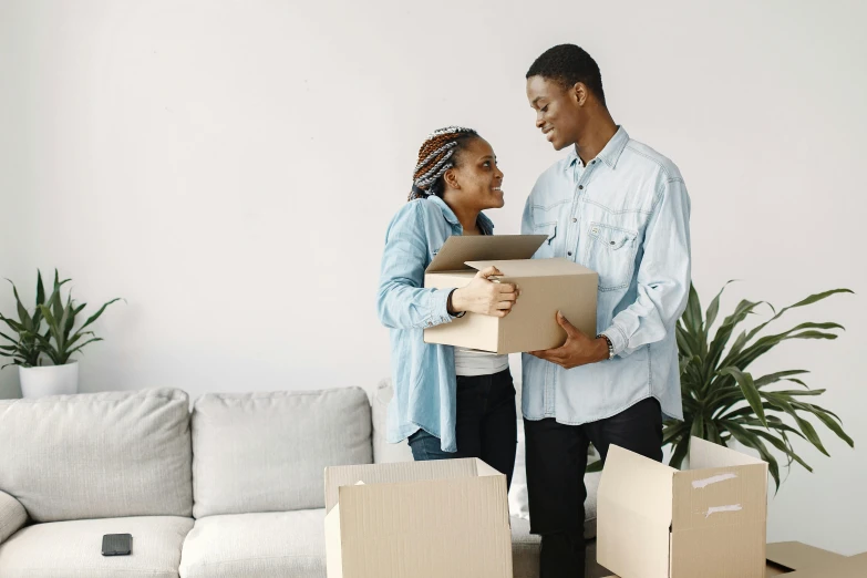 a young couple moving boxes in the living room