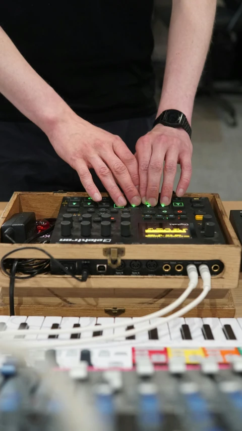 a person is touching a wooden keyboard with green lights