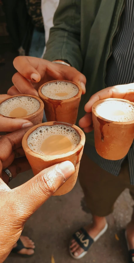 several people holding mugs of different kinds of beverages