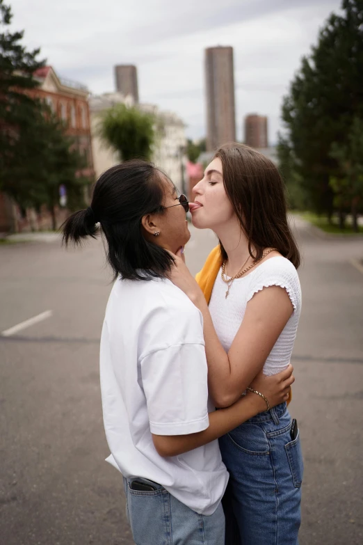 two women are standing in the street kissing