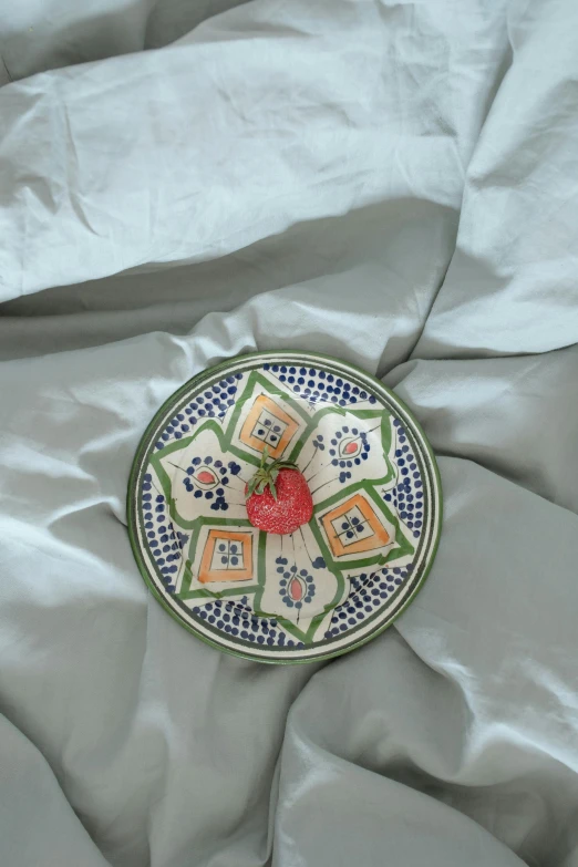 a bowl with an iron heart in the middle of a quilt