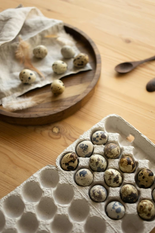 an egg tray with eggs and a wooden spoon