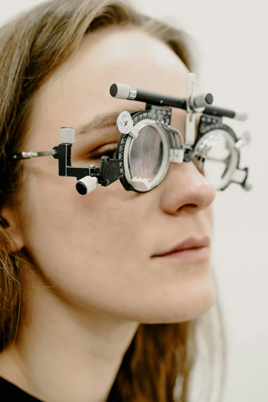 a woman wearing glasses is looking through the camera