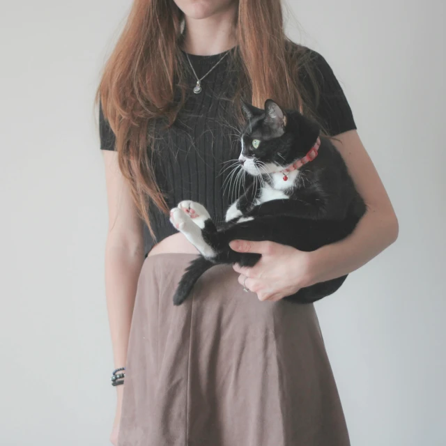 the woman is holding a cat and showing it's belly