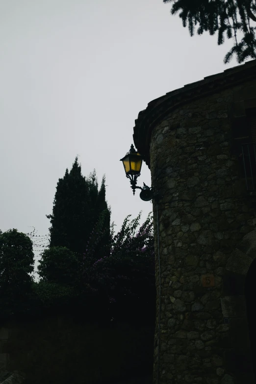 a lamppost attached to a building near trees