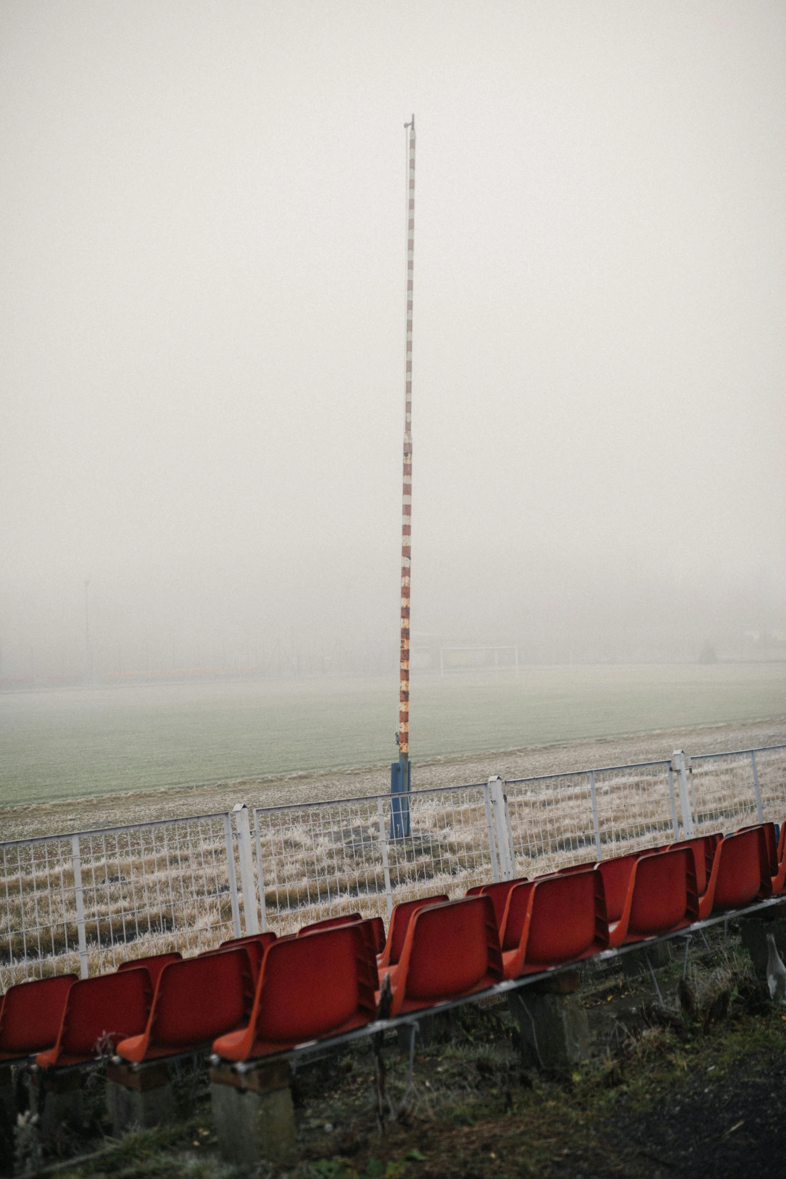 a foggy day with red seats at a baseball stadium