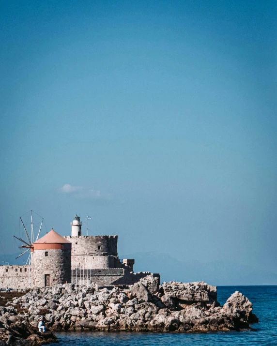 a tall lighthouse sitting on top of a rocky cliff