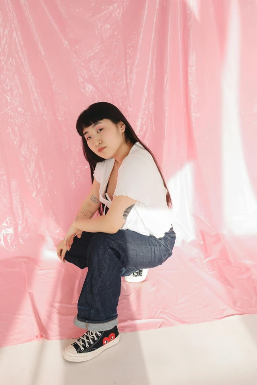 a young lady posing for a po with a pink background