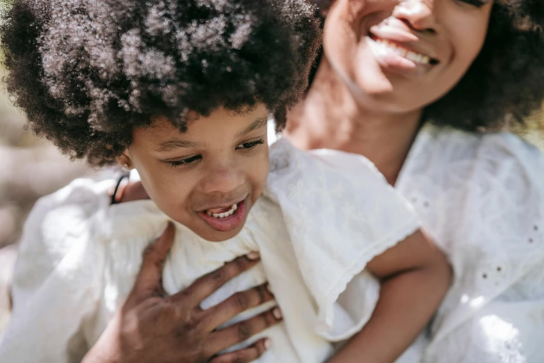 a woman holding a little girl in her arms