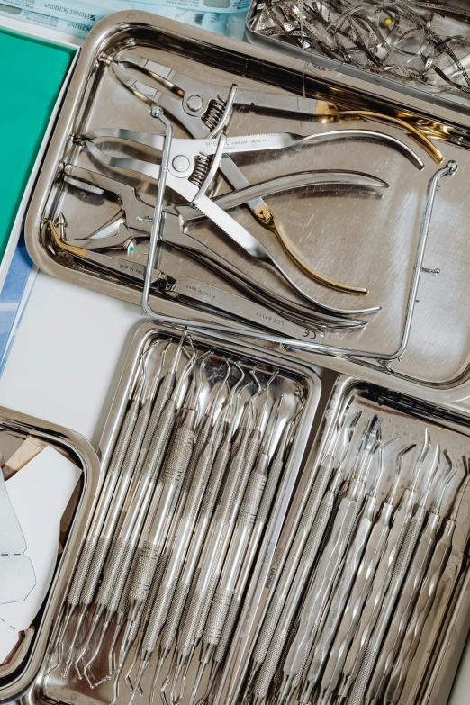 a silver tray holding multiple surgical instruments in metal tins